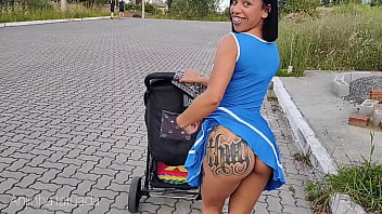 Mamãe deliciosa de vestido azul sem calsinha durante passeio na rua.